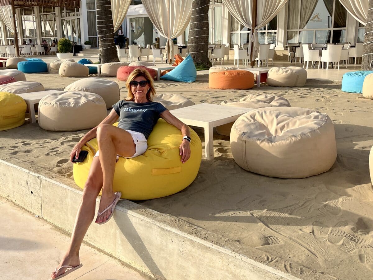 Ivča sitting on a bean bag on the beach in Albania