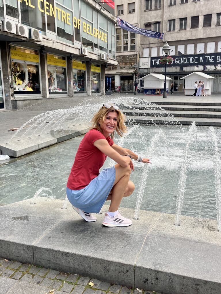 Ivča sitting in front of the water fountain in Belgrade